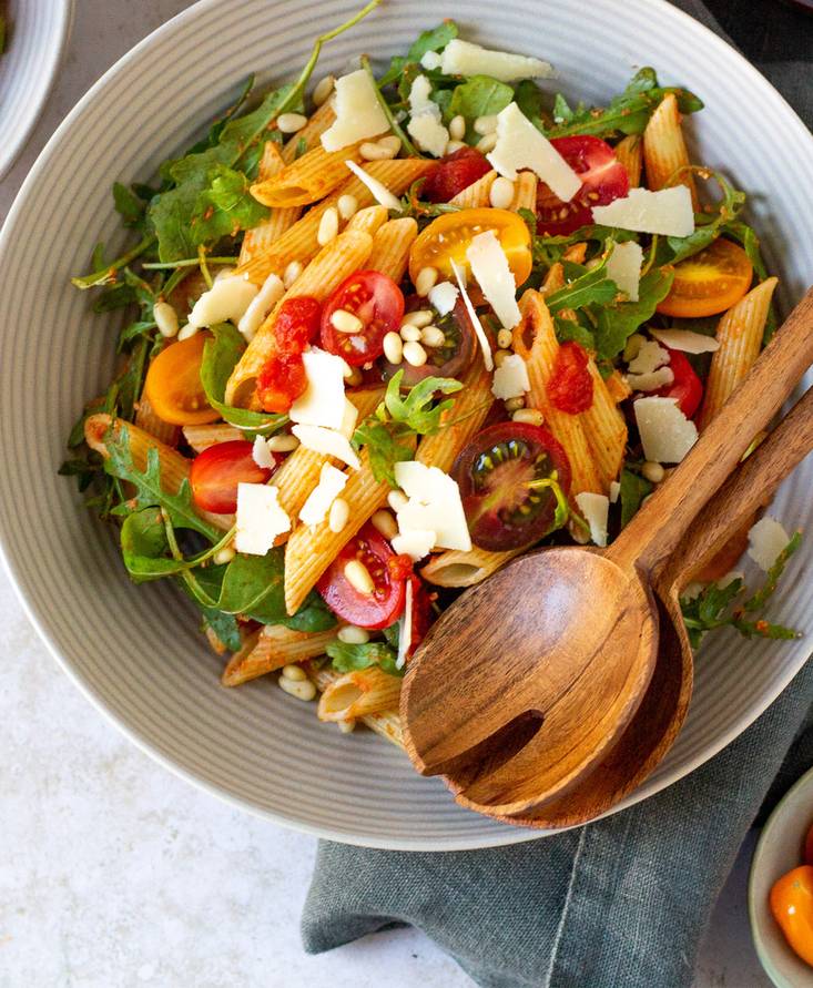 Ensalada de pasta con pesto rojo, rúcula y parmesano