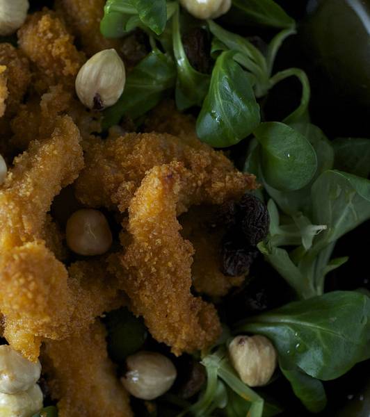 Straccetti di pollo panati al pane e pomodoro, uvetta e nocciole